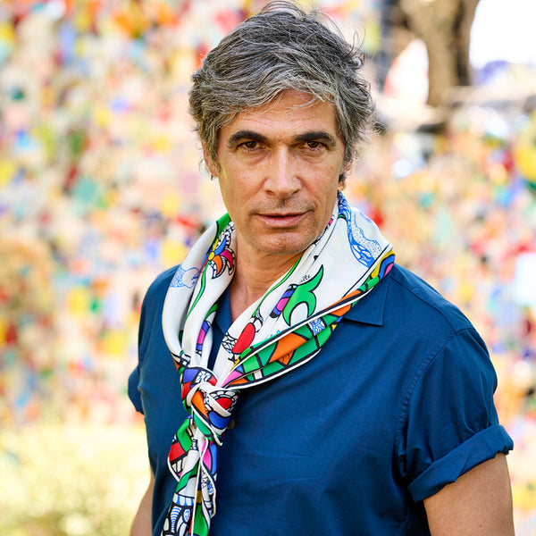 Man wearing the rossignol scard designed by Niki de Saint Phalle draped around his neck. 